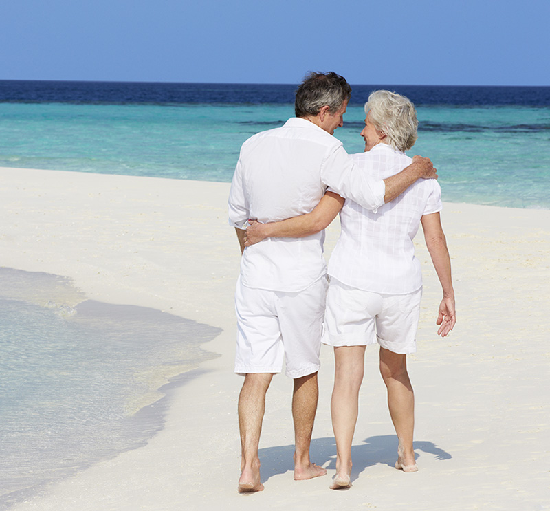 Old couple walking on the beach