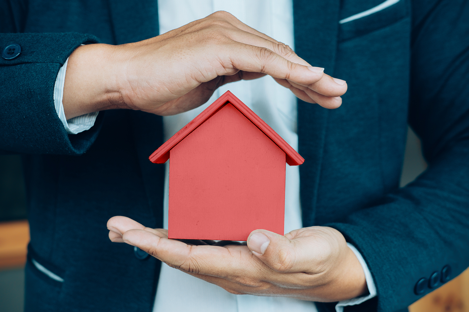 Man Holding Small Red Home in Hand